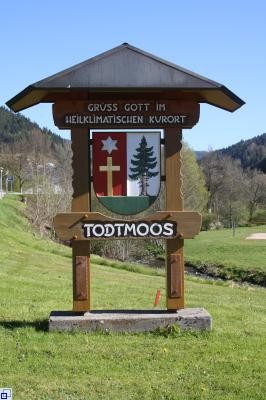 Ortseingangsschild Gemeinde Todtmoos aus Holz mit einem Dach. Abgebildet ist das Todtmooser Wappen