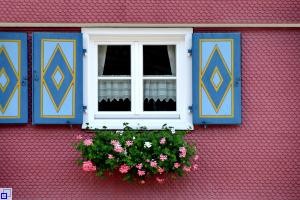 Fenster eines Bauernhauses mit Blumen